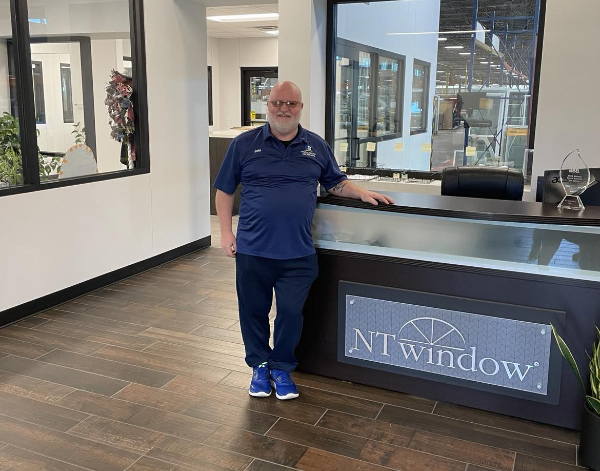 About Us - The owner of Premier Windows standing in the NT Window showroom, showcasing a commitment to quality window solutions.