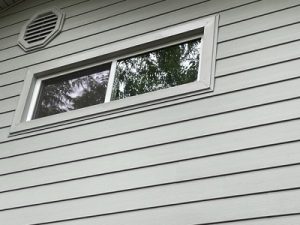 Close-up of durable, low-maintenance siding with a professionally installed window, showcasing Premier Windows' siding and window replacement services.